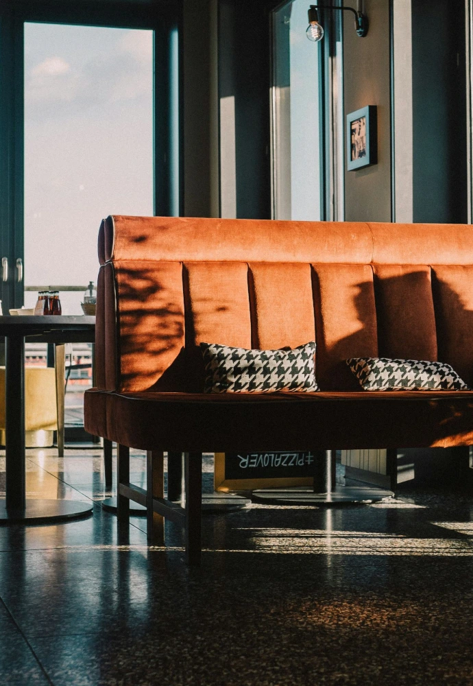a couch sitting in front of a window next to a table